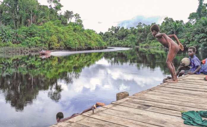 Anak-anak berenang di sungai di Mappi, Papua.