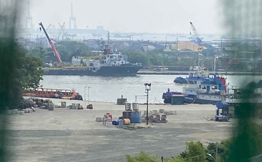 Pemandangan dari lantai 5 Rusunawa Marunda Blok D3 pada 3 Agustus 2022 di pelabuhan Marunda. Terpal biru menutupi tempat penumpukan (stockpile) batu bara, (Foto: Amandra Megarani)